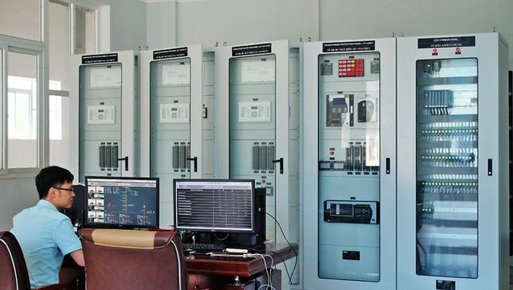 Substation operator sitting in a control room with protection panels