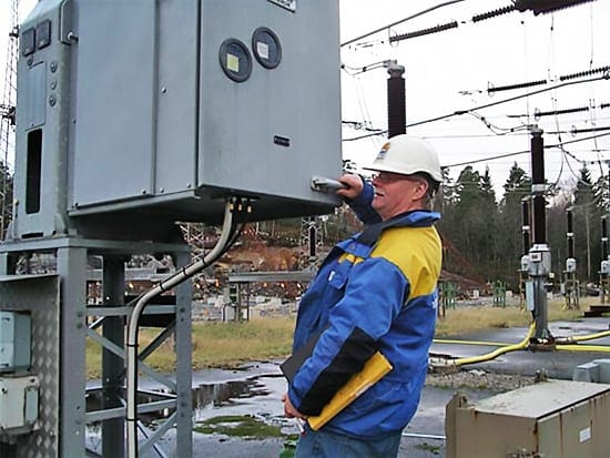 Serviceman is just about to open the door to the control unit of a breaker