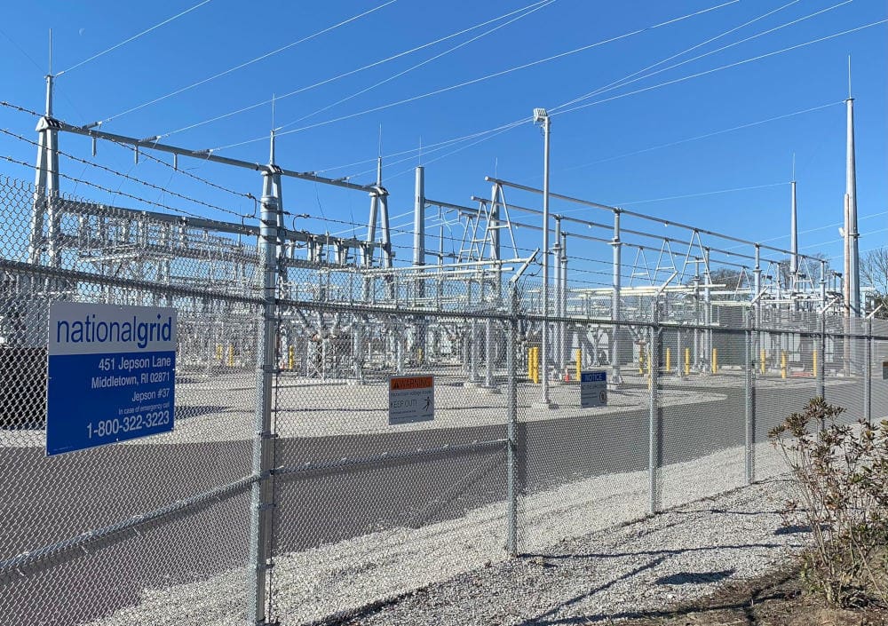 The interior of the substation is visible through the chain-link fence