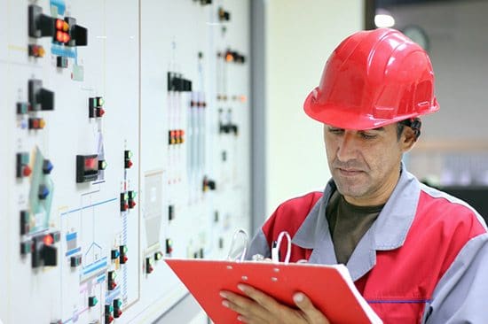 Energy assesment in industry facility. Personel checking a control panel.