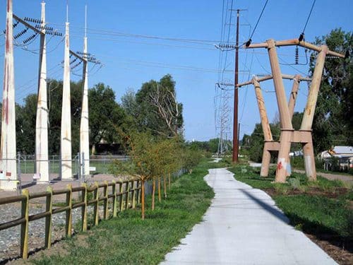 Transmission towers next to bikeway and metal fences